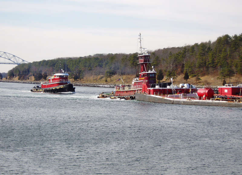 A tug escorts an oil barge through Cape Cod Canal
