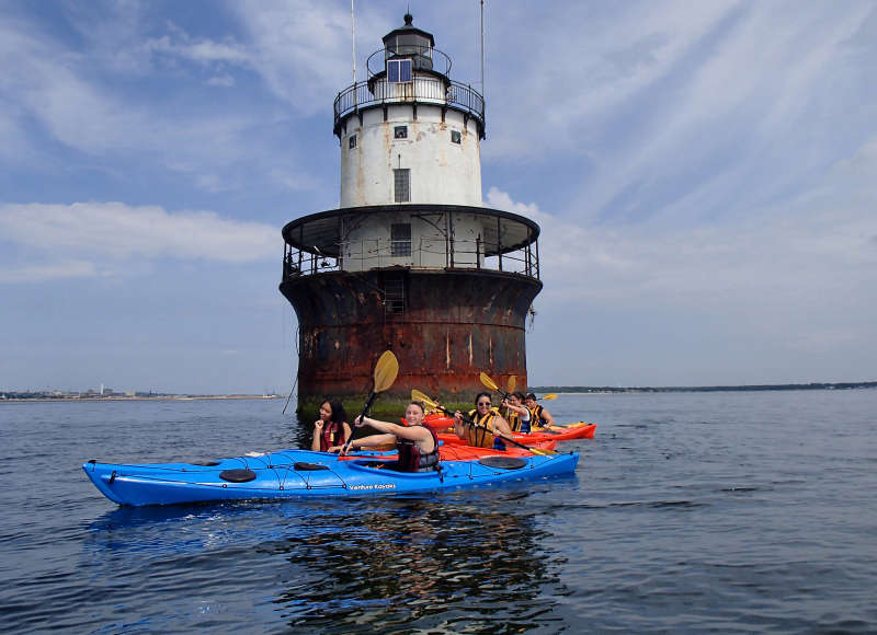 teens in kayaks next to Butler Flats Lighthouse in New Bedford