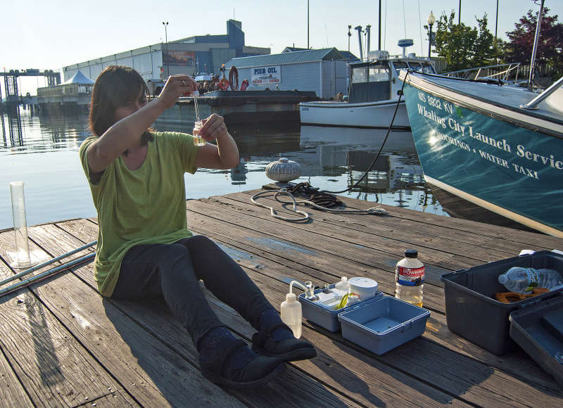 a woman testing the water in New Bedford Harbor