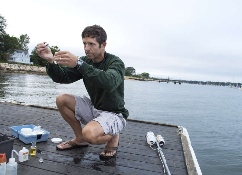 a man testing water health in Apponagansett Bay
