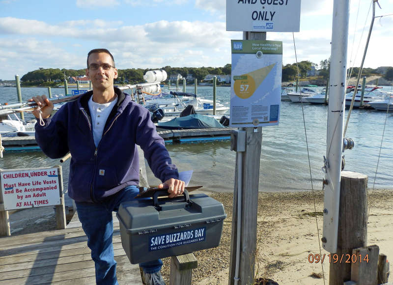 a man holding his water testing sampling pole and kit on Buttermilk Bay