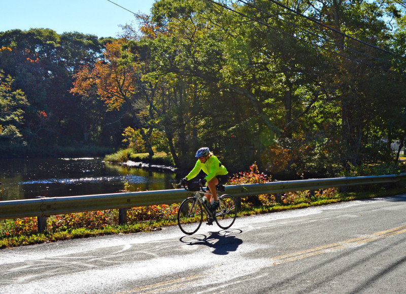 a woman bikes past the river