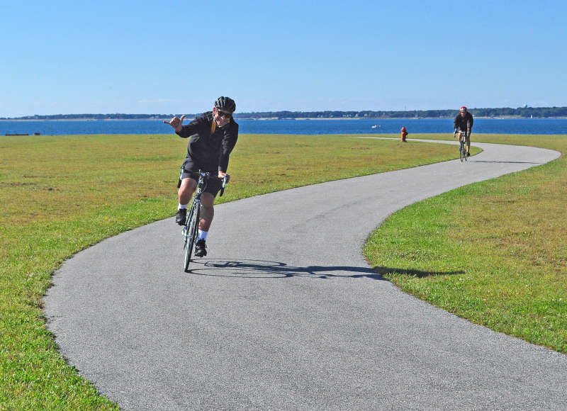 a smiling man bikes at Fort Taber in New Bedford