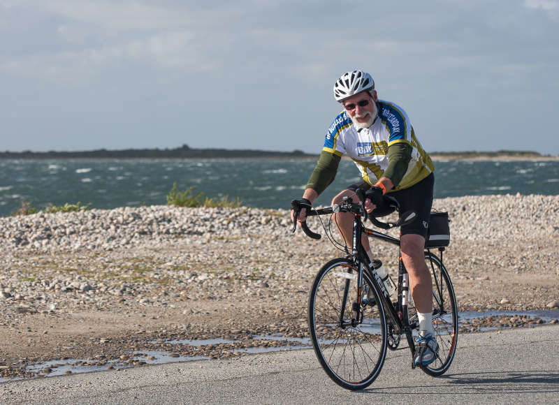a man biking past the water in Westport