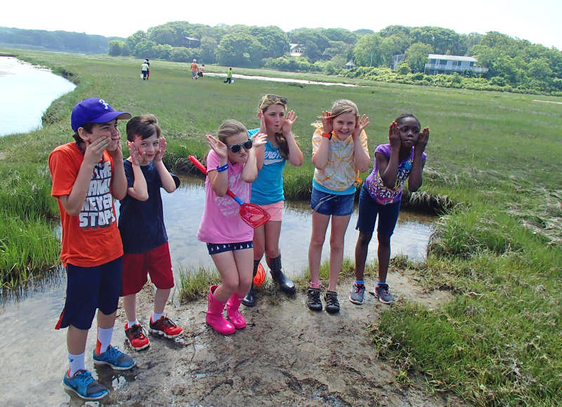 kids being silly in a salt marsh on Cape Cod