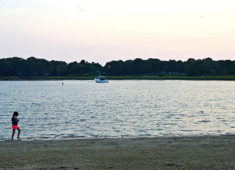 girl walking on Shell Point Beach in Wareham at sunset