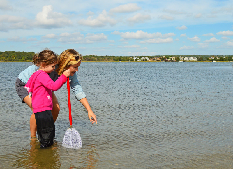 Woman and child wading in water at Apponagansett Park