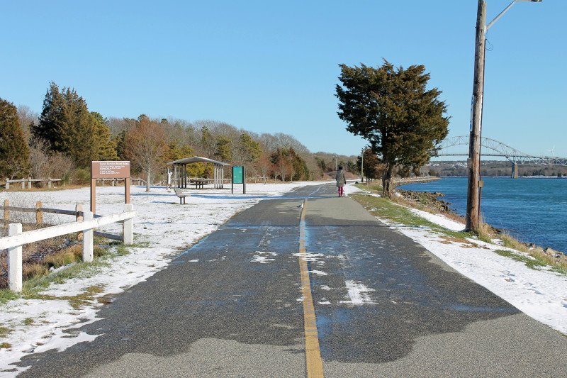 a woman walking along Cape Cod Canal at Buzzards Bay Recreation Area in Bourne