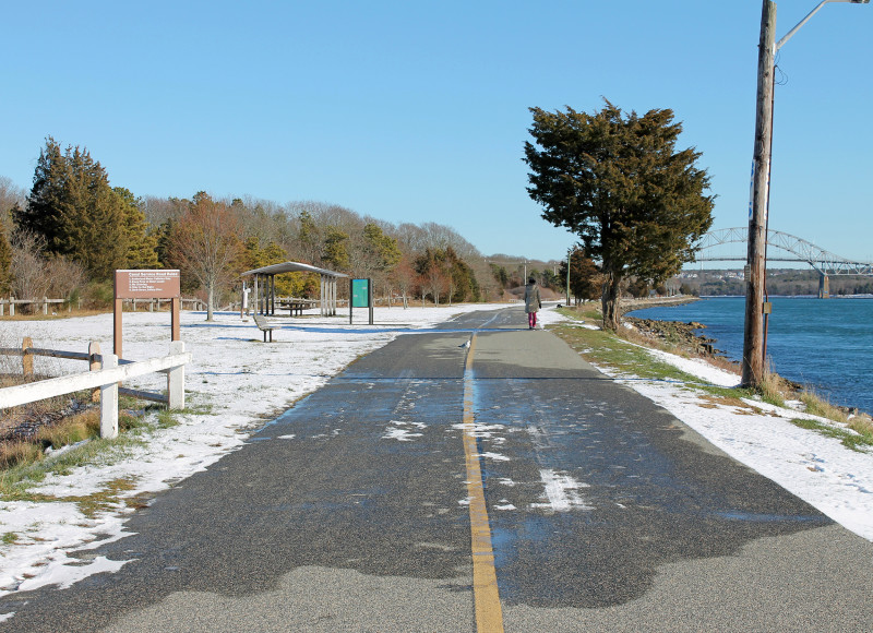 a woman walking along Cape Cod Canal at Buzzards Bay Recreation Area in Bourne