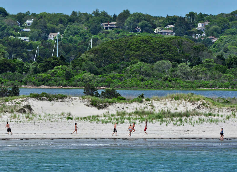 people walk along Cherry & Webb Beach in Westport