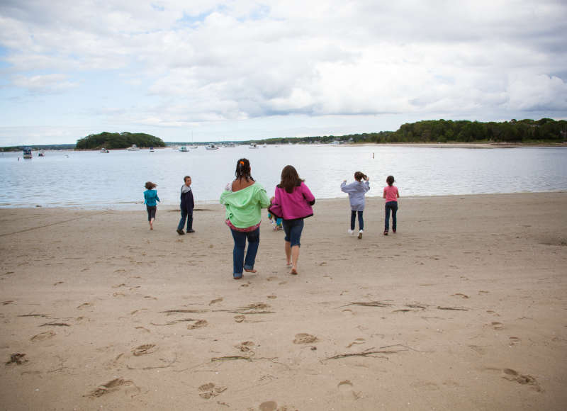 a group of kids walking toward the water at Onset Beach