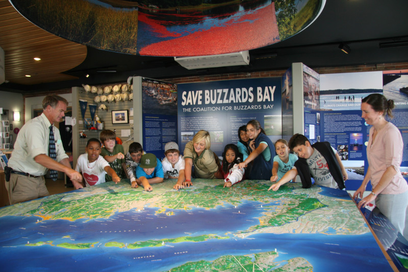 a group of kids gathered around a large map of Buzzards Bay