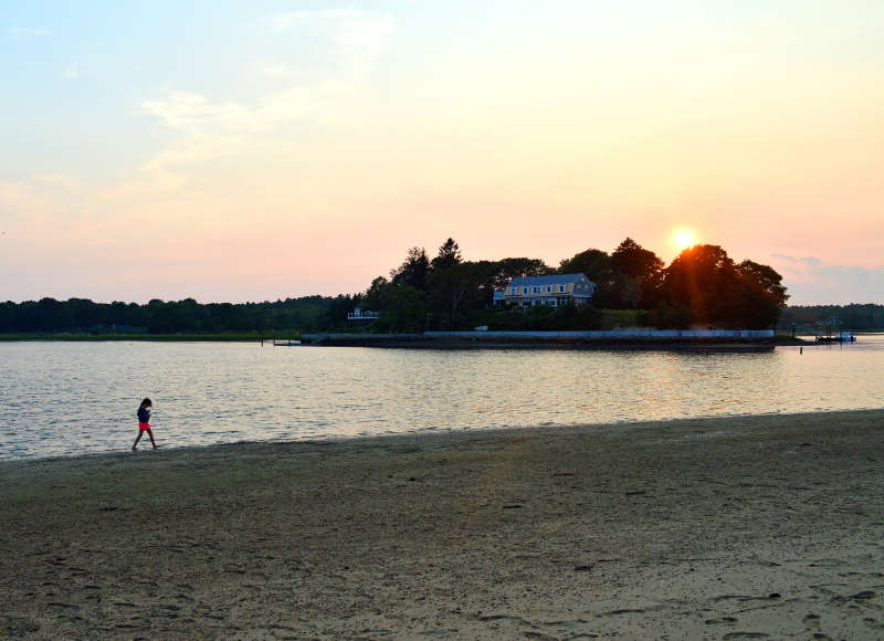 girl walking on Shell Point Beach at sunset