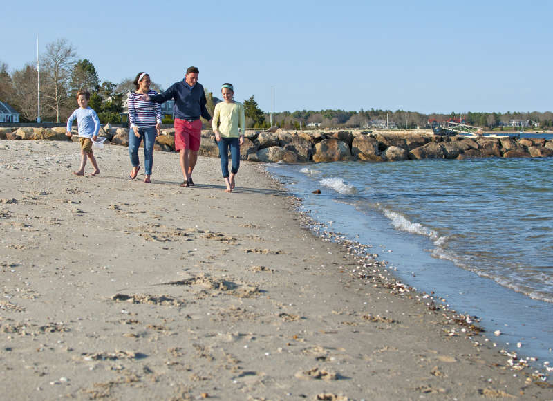 a family walks down the sand at Silvershell Beach in Marion