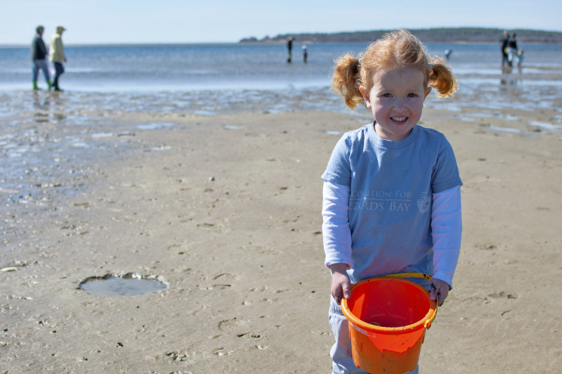 little girl holding a beach pail