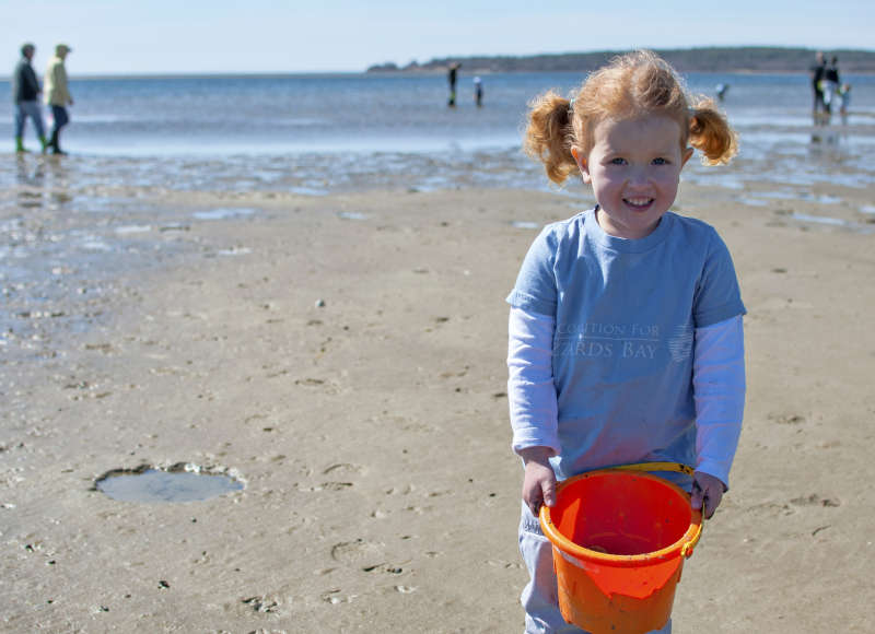 little girl holding a beach pail