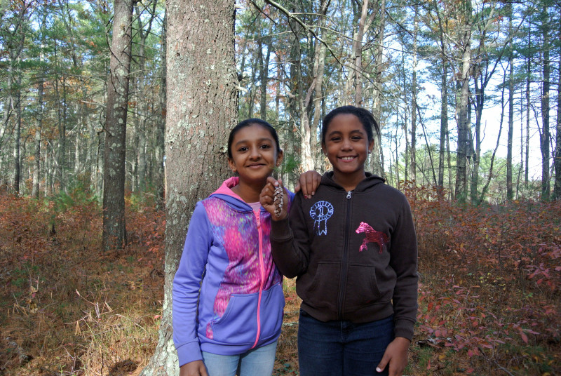 two girls holding a pine cone in William Minot Forest