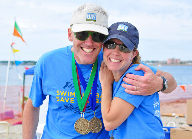 two people wearing Buzzards Bay Coalition merchandise on a beach in Fairhaven