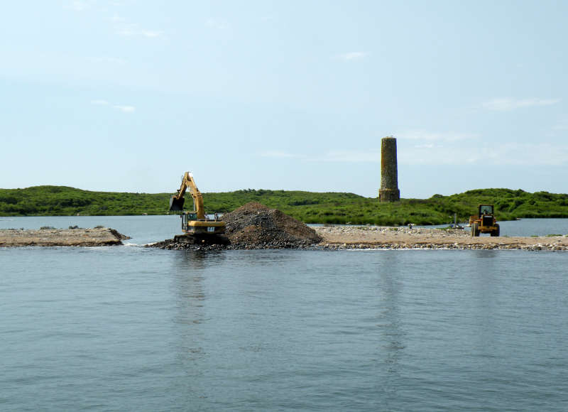 an excavator digging a connection from Cuttyhunk West End Pond to Buzzards Bay