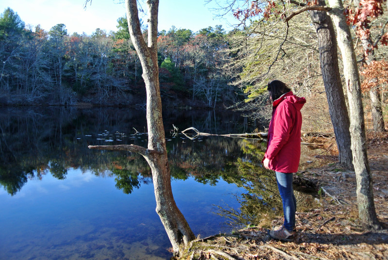 a woman stands by the edge of a pond at Four Ponds Conservation Area in Bourne