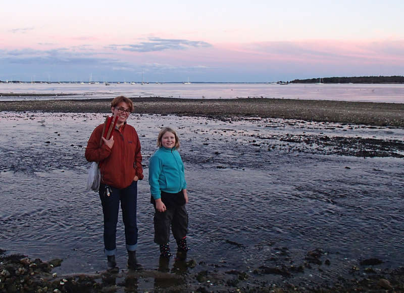 a mother and daughter standing at the beach in Mattapoisett at sunset