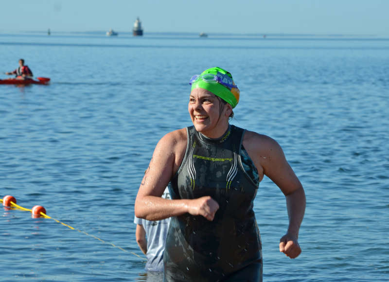 a woman coming out of the water at the Buzzards Bay Swim finish line
