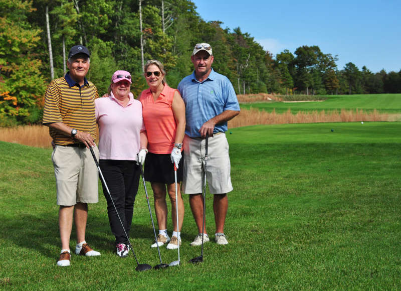 four golfers standing on the grass at The Bay Club in Mattapoisett