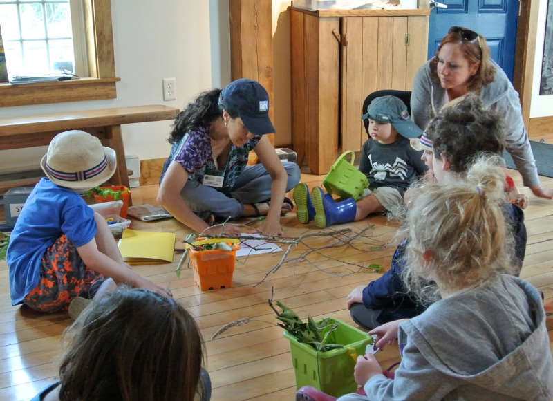 kids and parents sitting in a circle in the learning center at The Sawmill in Acushnet