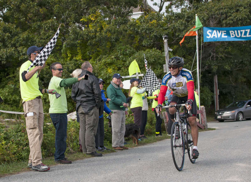 man cycles past the finish line at the Buzzards Bay Watershed Ride