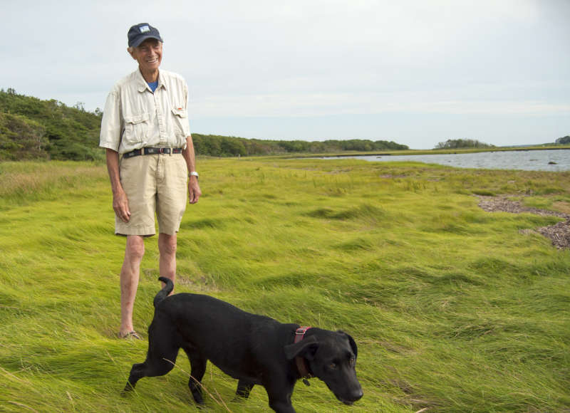 Horace Field and his black Lab in the salt marsh on Brandt Island Cove in Mattapoisett