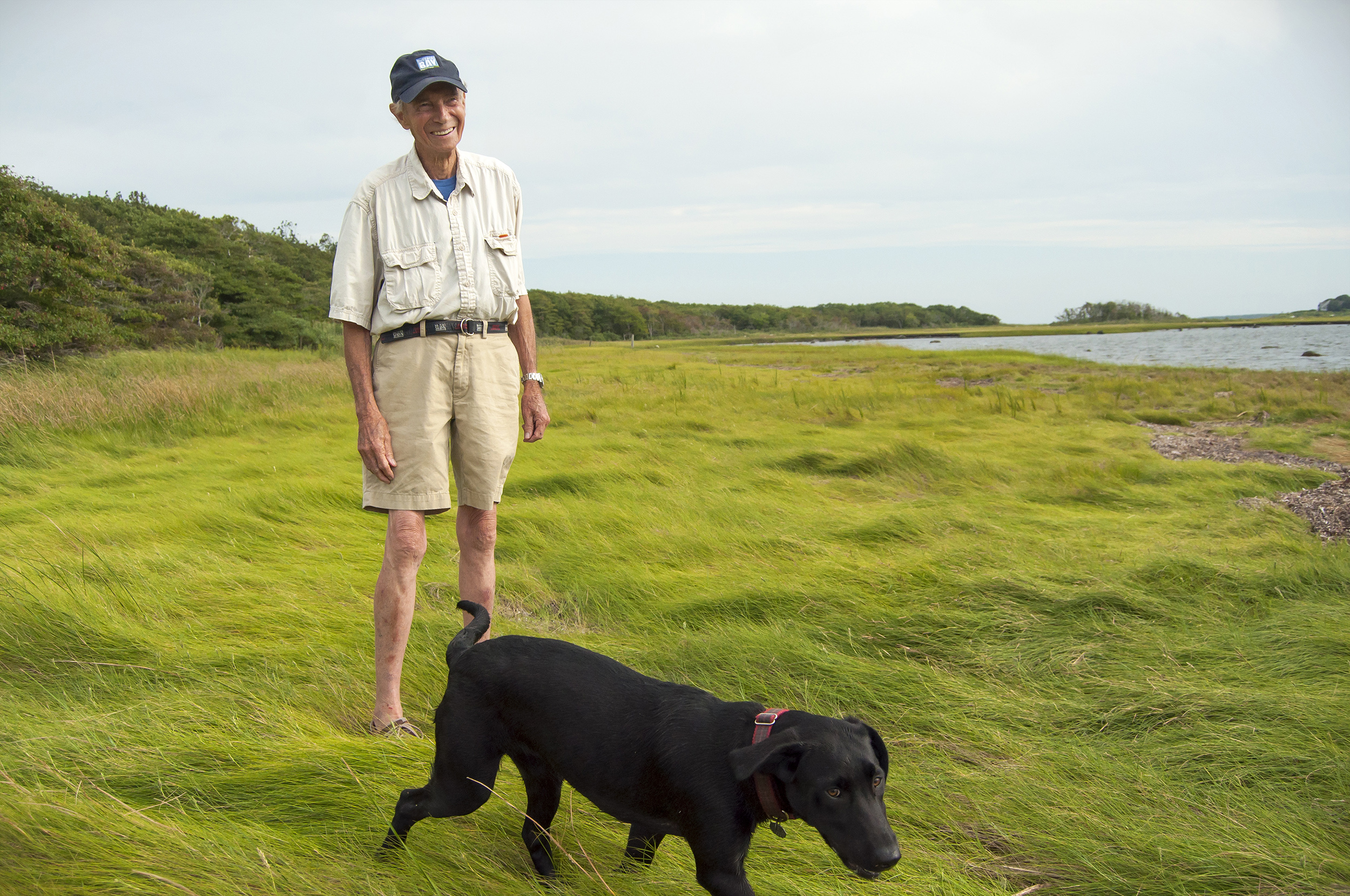 Horace Field and his black Lab in the salt marsh on Brandt Island Cove in Mattapoisett