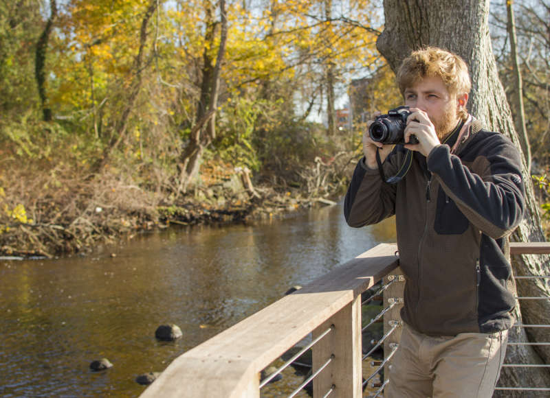 man taking a photo of the Acushnet River at The Sawmill