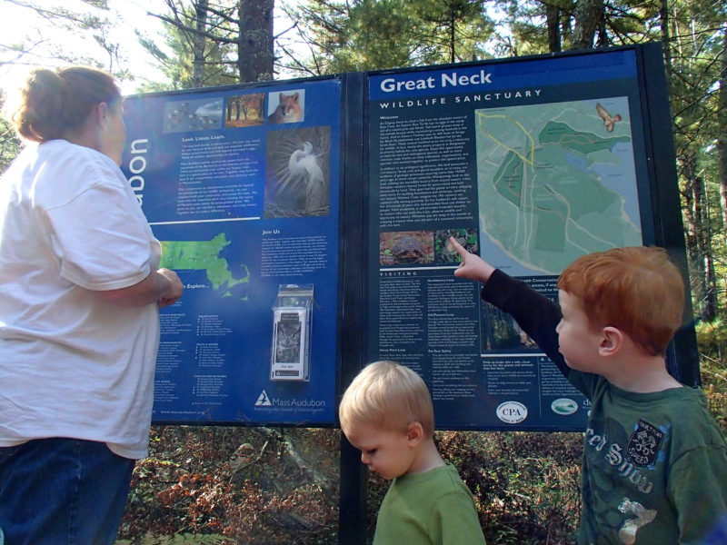 a family looking at a trail map sign at Great Neck Wildlife Sanctuary
