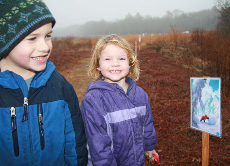 two kids on a storybook walk at a trail in Mattapoisett
