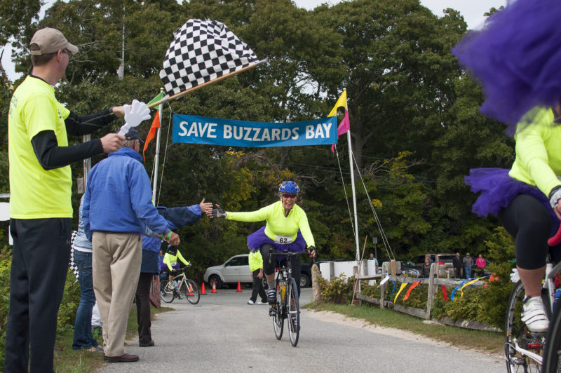 woman crossing the finish line at the Buzzards Bay Watershed Ride