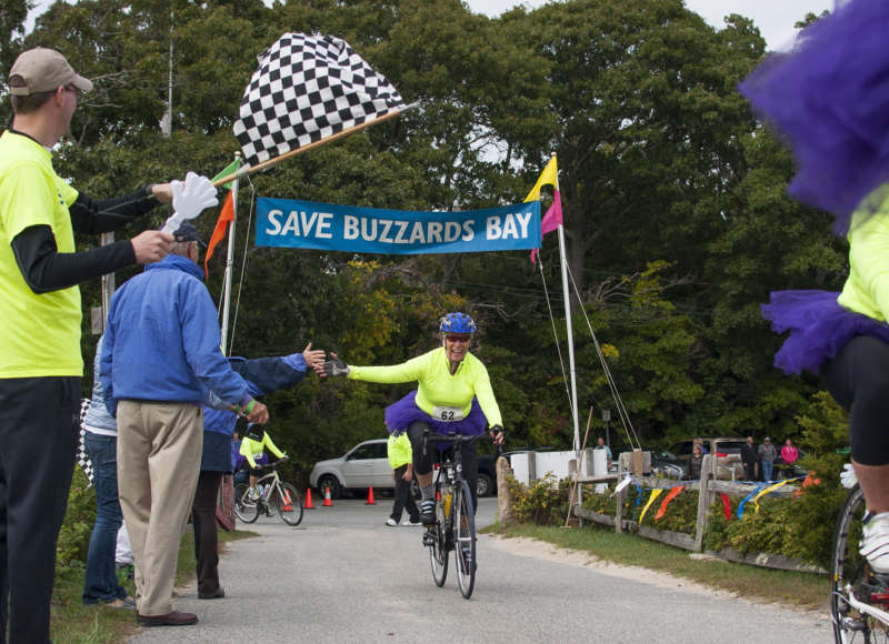 woman crossing the finish line at the Buzzards Bay Watershed Ride