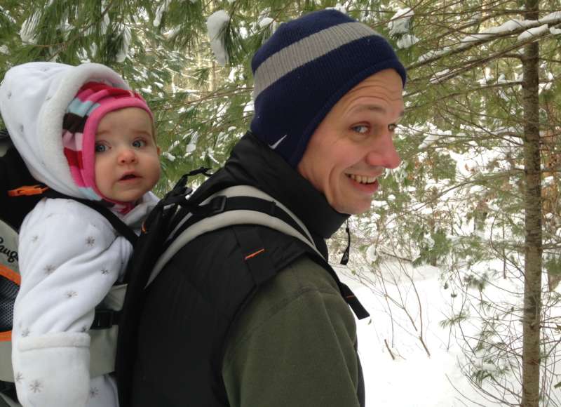 father with baby daughter hiking in the snow