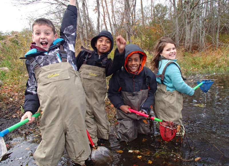 a group of kids in waders exploring the Acushnet River