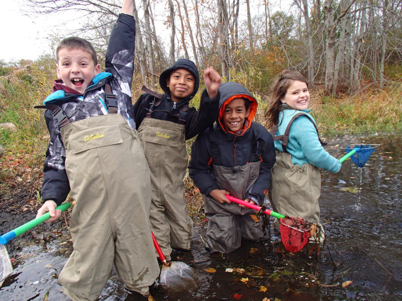 a group of kids in waders exploring the Acushnet River