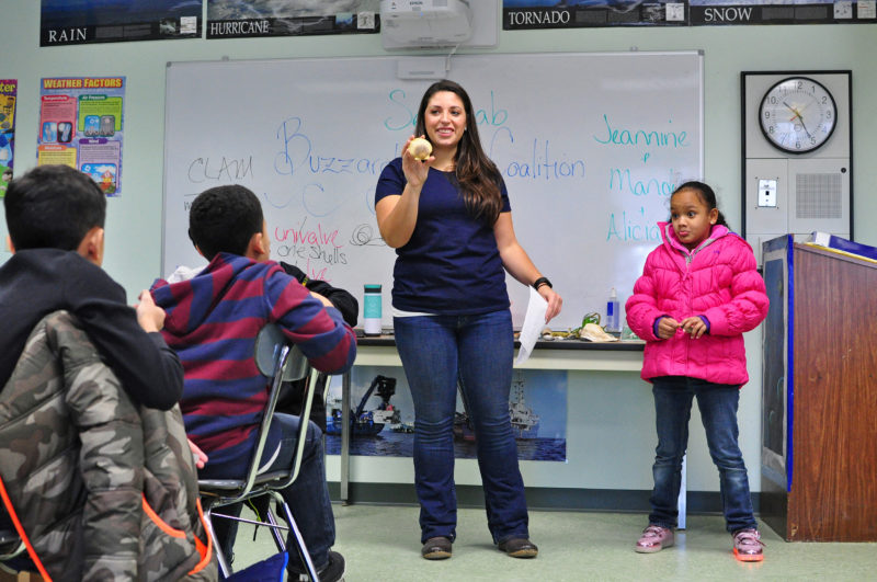 educator and student with a scallop shell in a science classroom