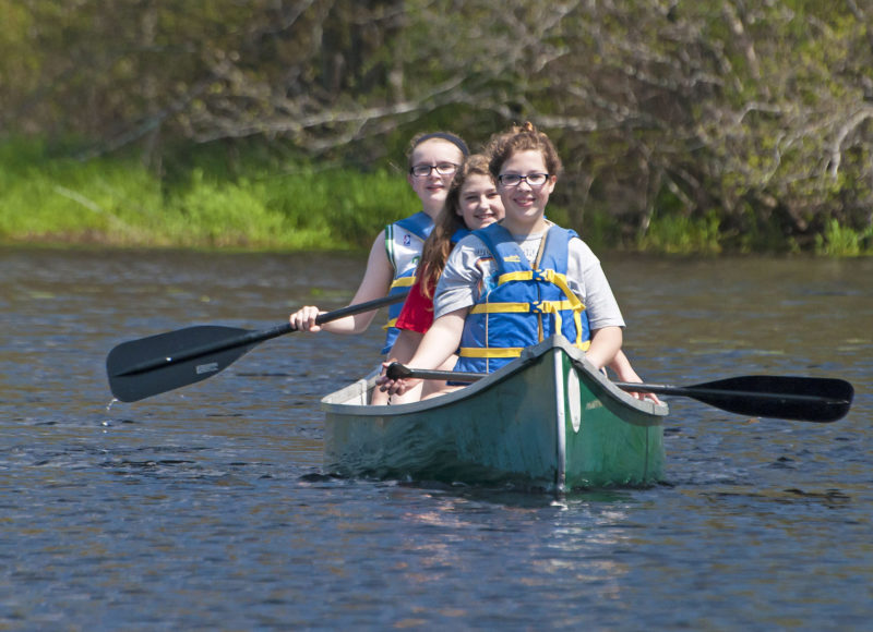 three girls canoeing on the Acushnet River at The Sawmill