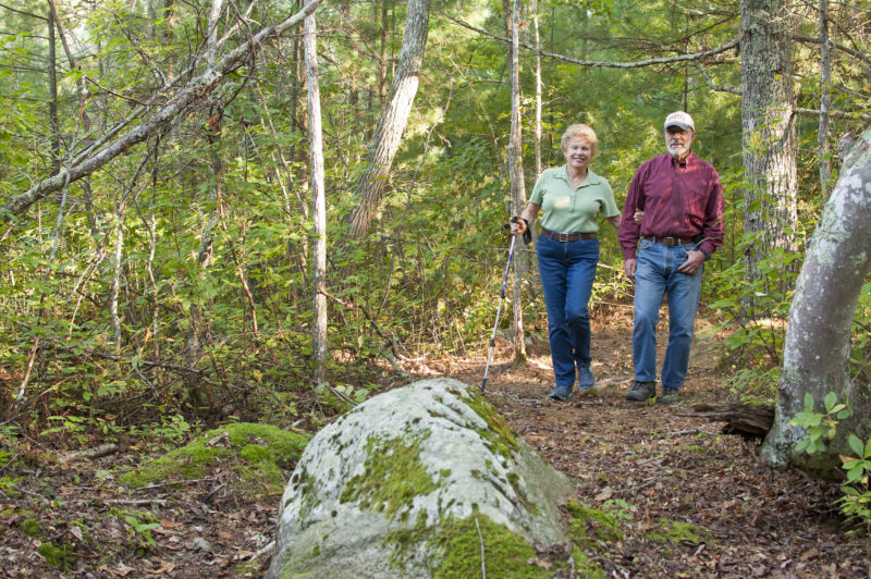 two people walking on a wooded trail at Brandt Island Cove District in Mattapoisett