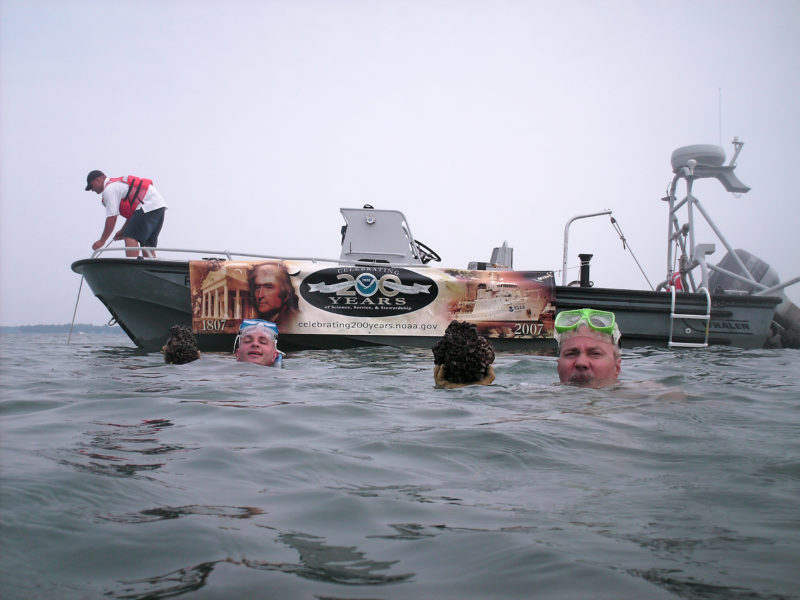 NOAA scientists in the water holding mussels