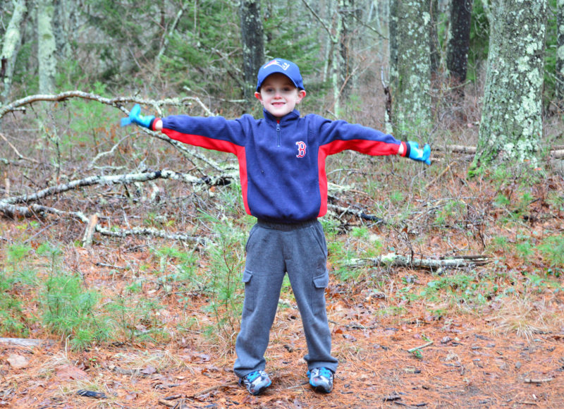young boy playing in the woods at William Minot Forest in Wareham
