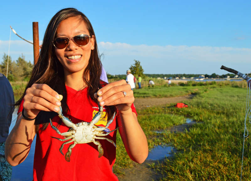 woman holding a blue crab at Eel Pond in Mattapoisett