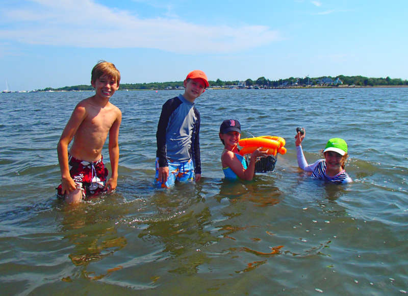 kids in the water in Mattapoisett with a basket of quahogs