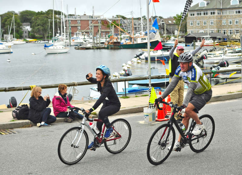 cyclists crossing finish line in Woods Hole at Buzzards Bay Watershed Ride