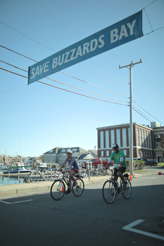 two cyclists cross the Buzzards Bay Watershed Ride finish line in Woods Hole
