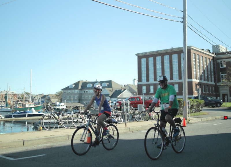 two cyclists cross the Buzzards Bay Watershed Ride finish line in Woods Hole