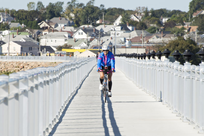 A woman riding her bike on the New Bedford CoveWalk during the Buzzards Bay Watershed Ride.